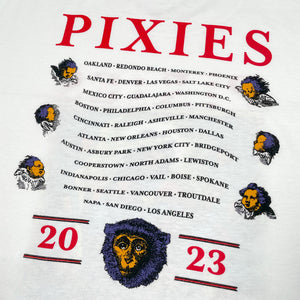 Close up of the back of a white t shirt against a white background with red text reading "Pixies." Listed below in a wave like pattern are all 2023 Tour dates with cherubs along the edge. Below that is a monkey head design and in red text the number "2023"