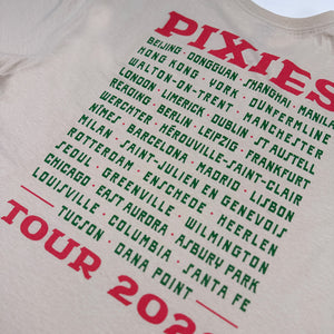 Close-up of green Pixies tour cities, including Dana Point, between red band lettering and Tour 2026 text on sand fabric.