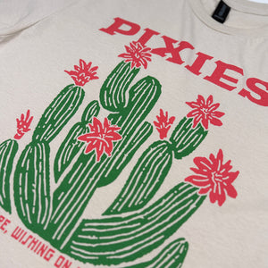Close-up of red Pixies lettering and the green cactus with red flowers on the sand Cactus Tour Tee.