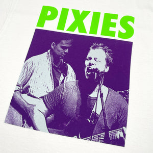 Close up of a white Pixies t-shirt with green "Pixies" Logo and a purple photo of band performing
