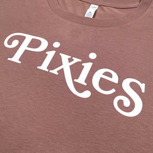 Close up of a hazy Pink Crop Top against a white background with white text reading "Pixies."