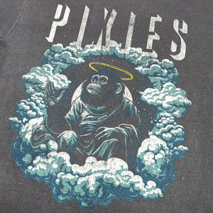Close up of a faded Black T-Shirt with distressed light gray text reading "Pixies" and a design of an angelic monkey sitting amongst clouds.